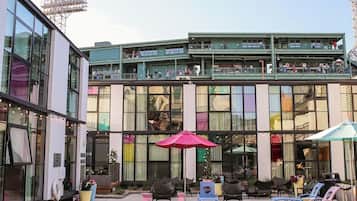 A modern building with a pool area, outdoor seating, and a stage.