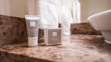 A bathroom counter with a tube of Laithé body cream and a bar of Laithé body soap.