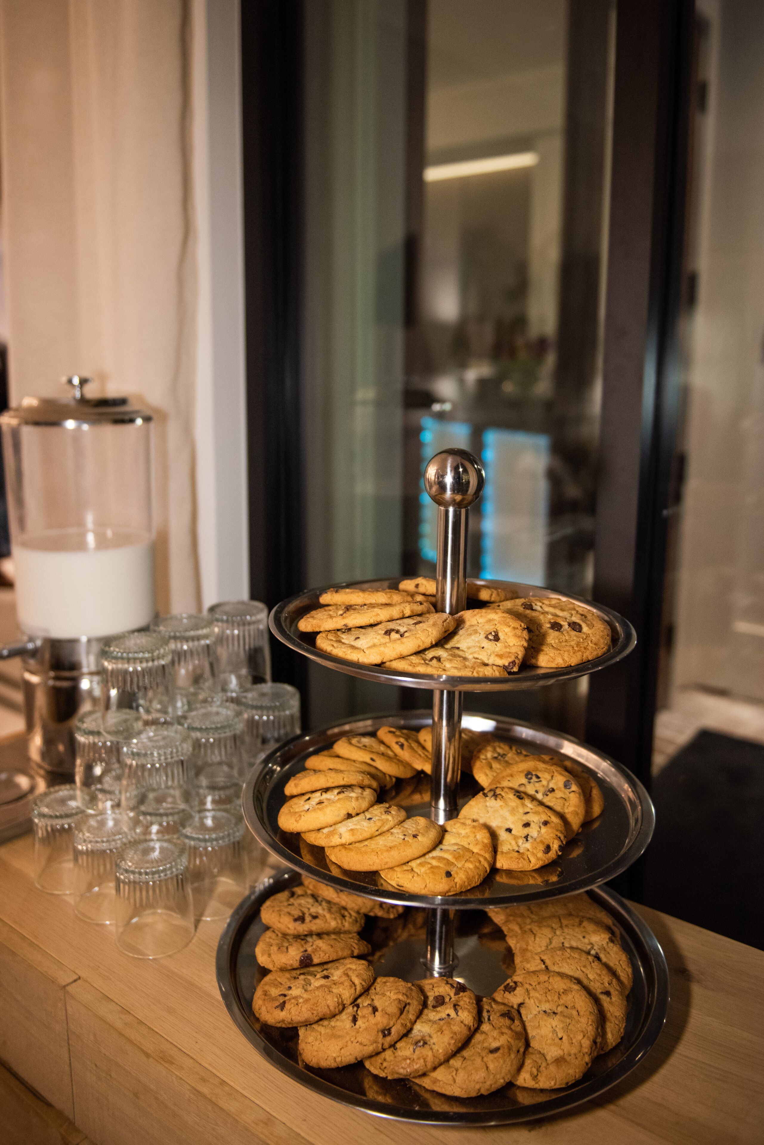 Une table de buffet avec trois niveaux de biscuits et plusieurs verres vides.