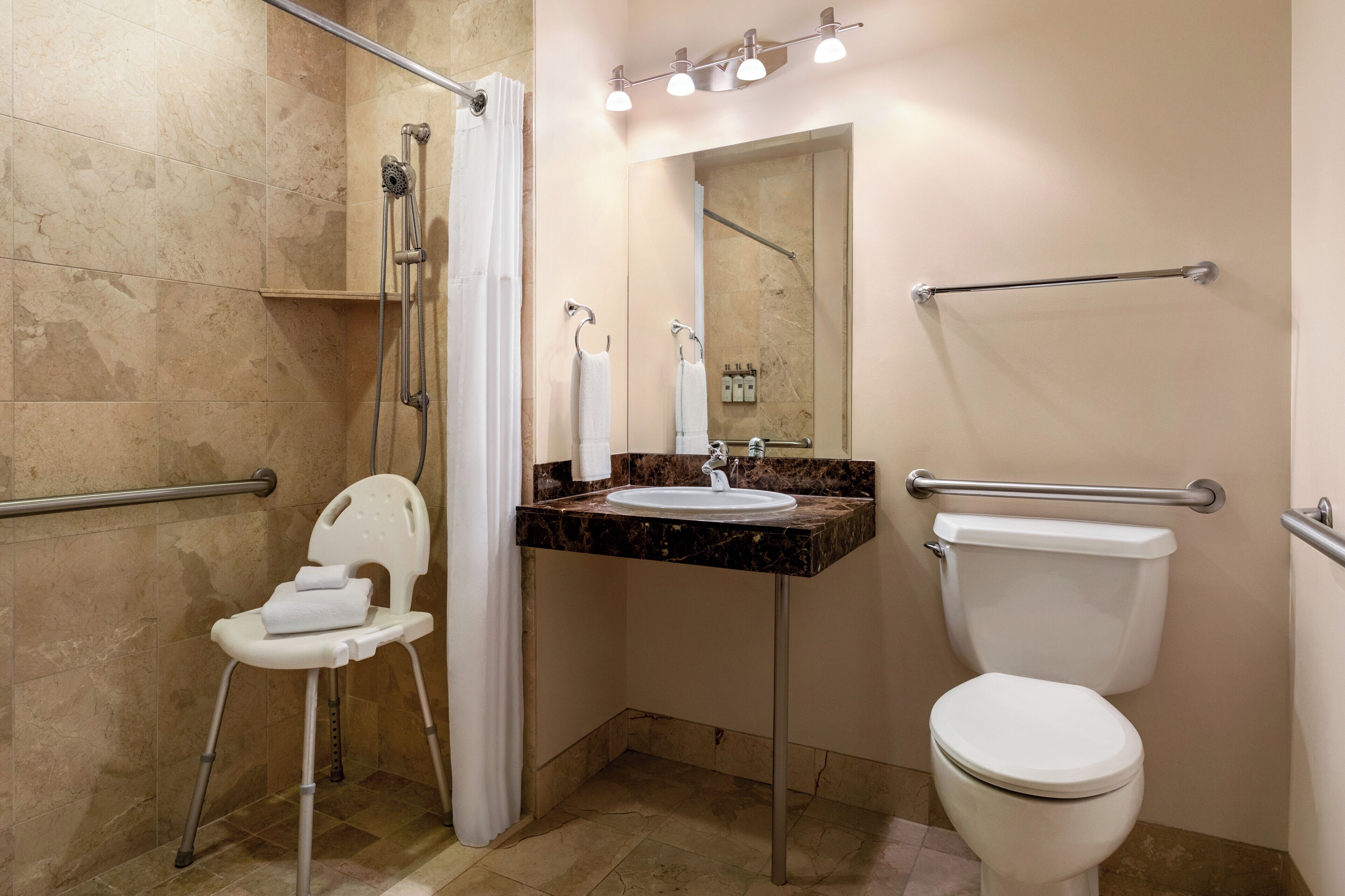 Een badkamer met douche, toilet en wastafel.