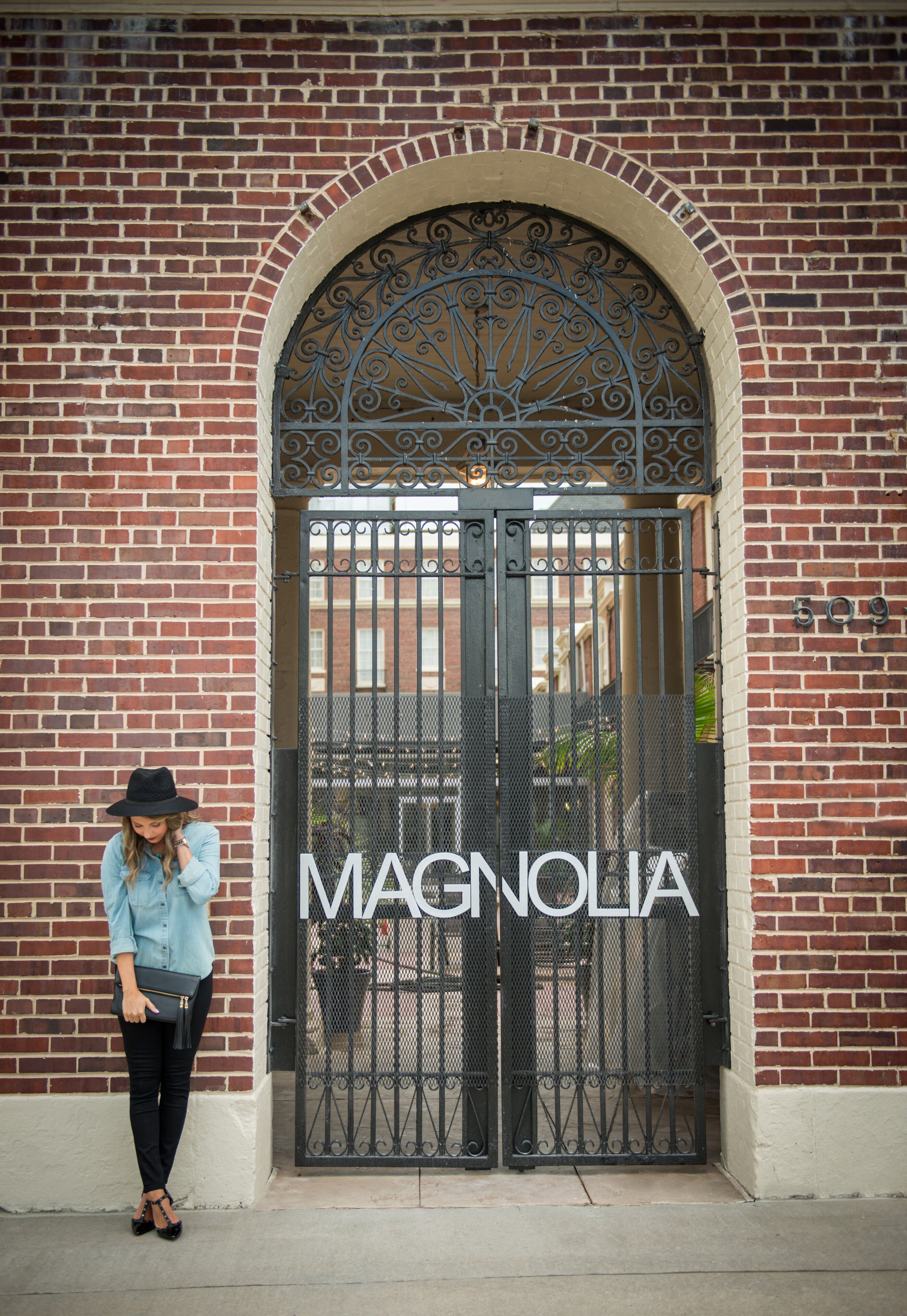 A brick building with a large arched entrance and a sign reading "MAGNOLIA".