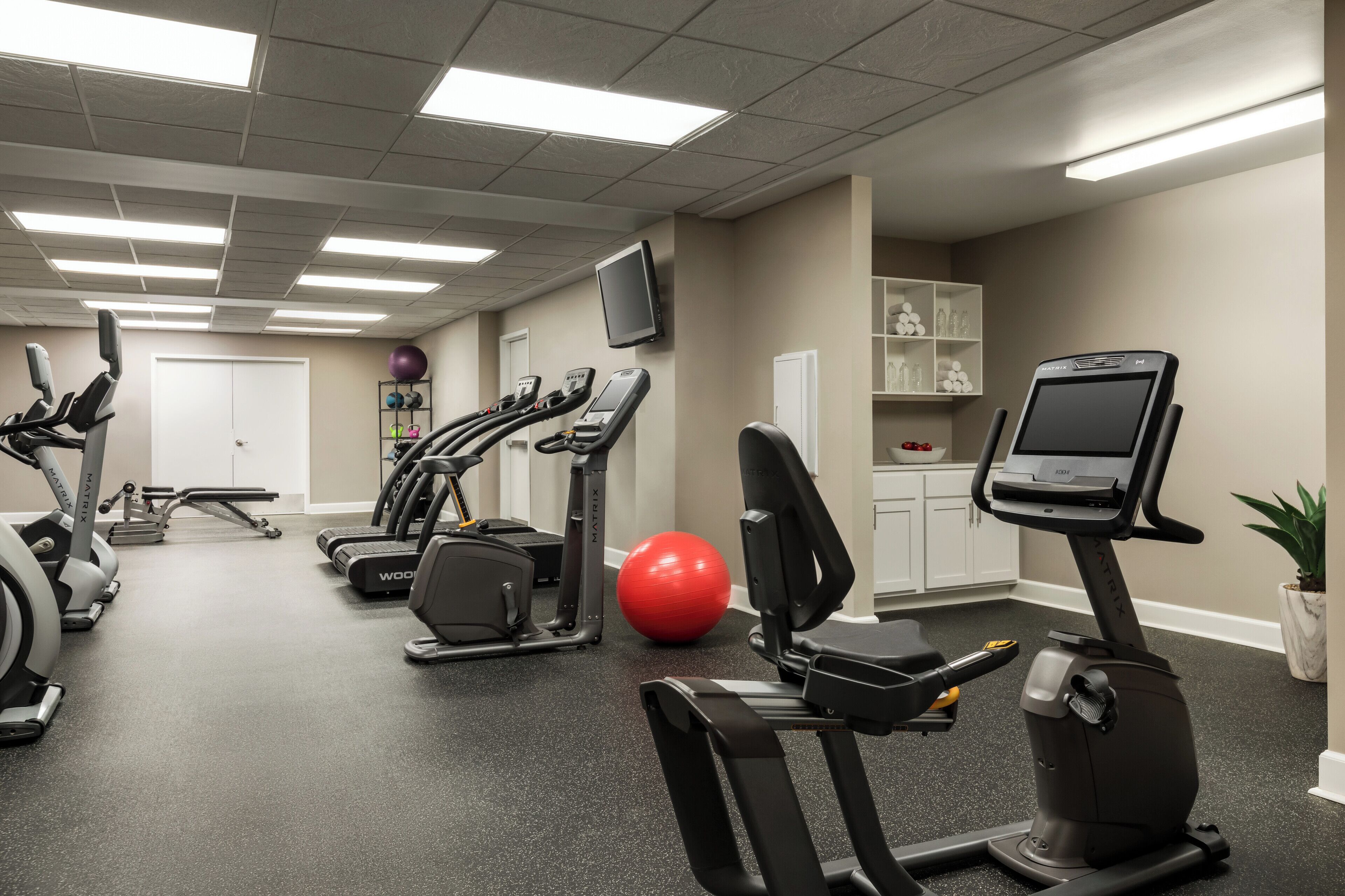 A gym with treadmills, elliptical machines, and a stationary bike.