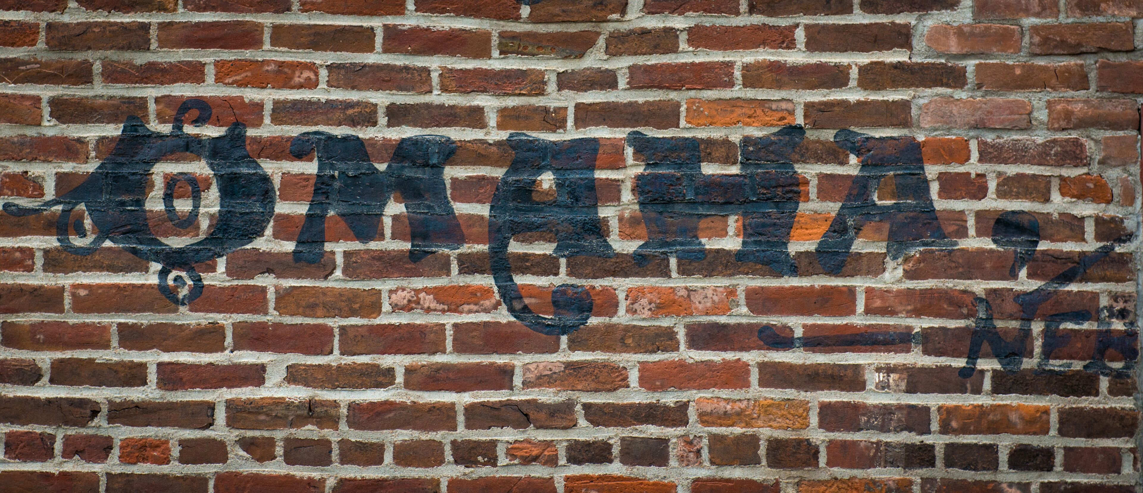 A brick wall with the word "OMAH" painted in black.