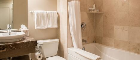 A bathroom with a sink, toilet, and bathtub.