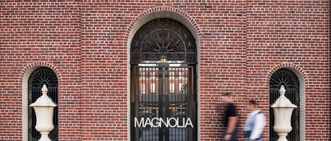 A brick building with a large arched entrance labeled "MAGNOLIA".