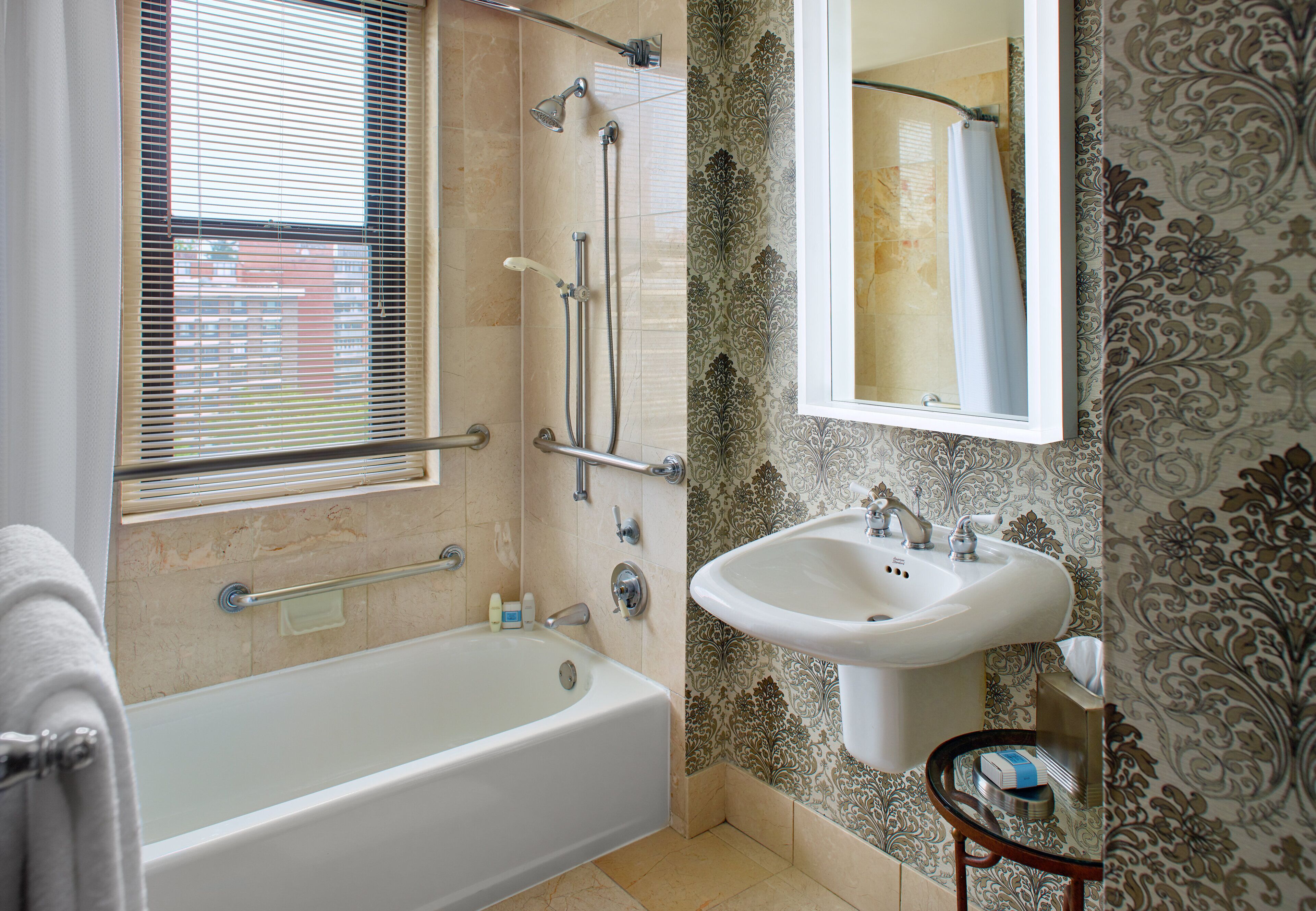 A bathroom with a bathtub, a sink, and a shower with a glass door.