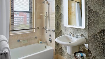 A bathroom with a bathtub, a sink, and a shower with a glass door.