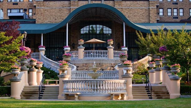 A grand entrance with a fountain, steps, and a balustrade leading to a building with a brick facade and large windows. - Omni Shoreham Hotel Washington DC (Washington)