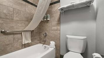 A bathroom with a bathtub, toilet, and towel rack.