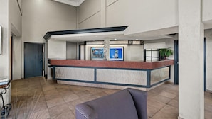 A reception area with a counter, framed artwork, and a seating area. - Best Western Desert Villa Inn (Barstow)