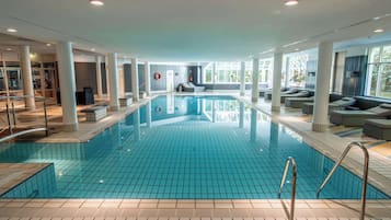 Una piscina techada, sillones reclinables de piscina