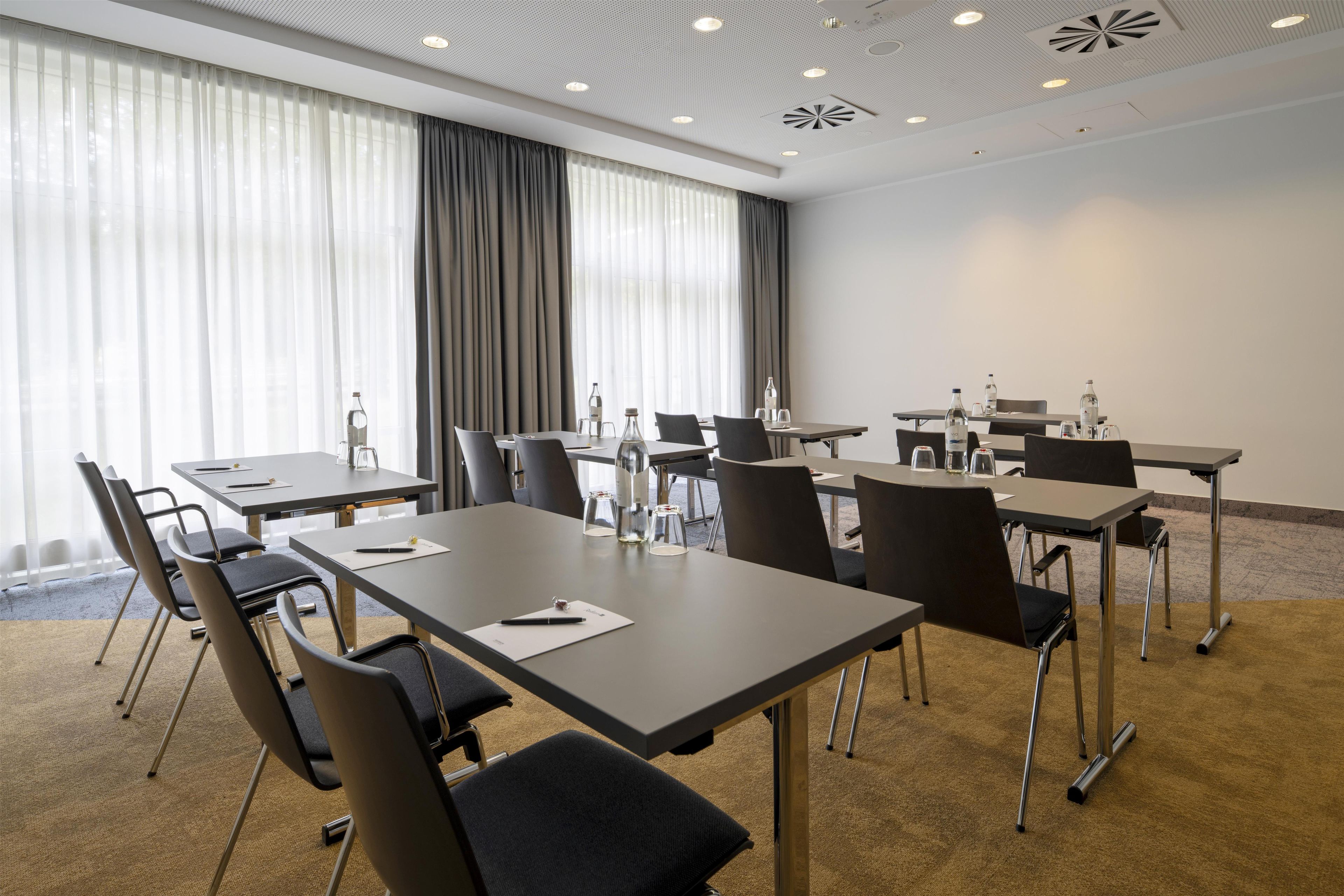 A conference room with tables, chairs, and water bottles.