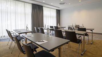 A conference room with tables, chairs, and water bottles.