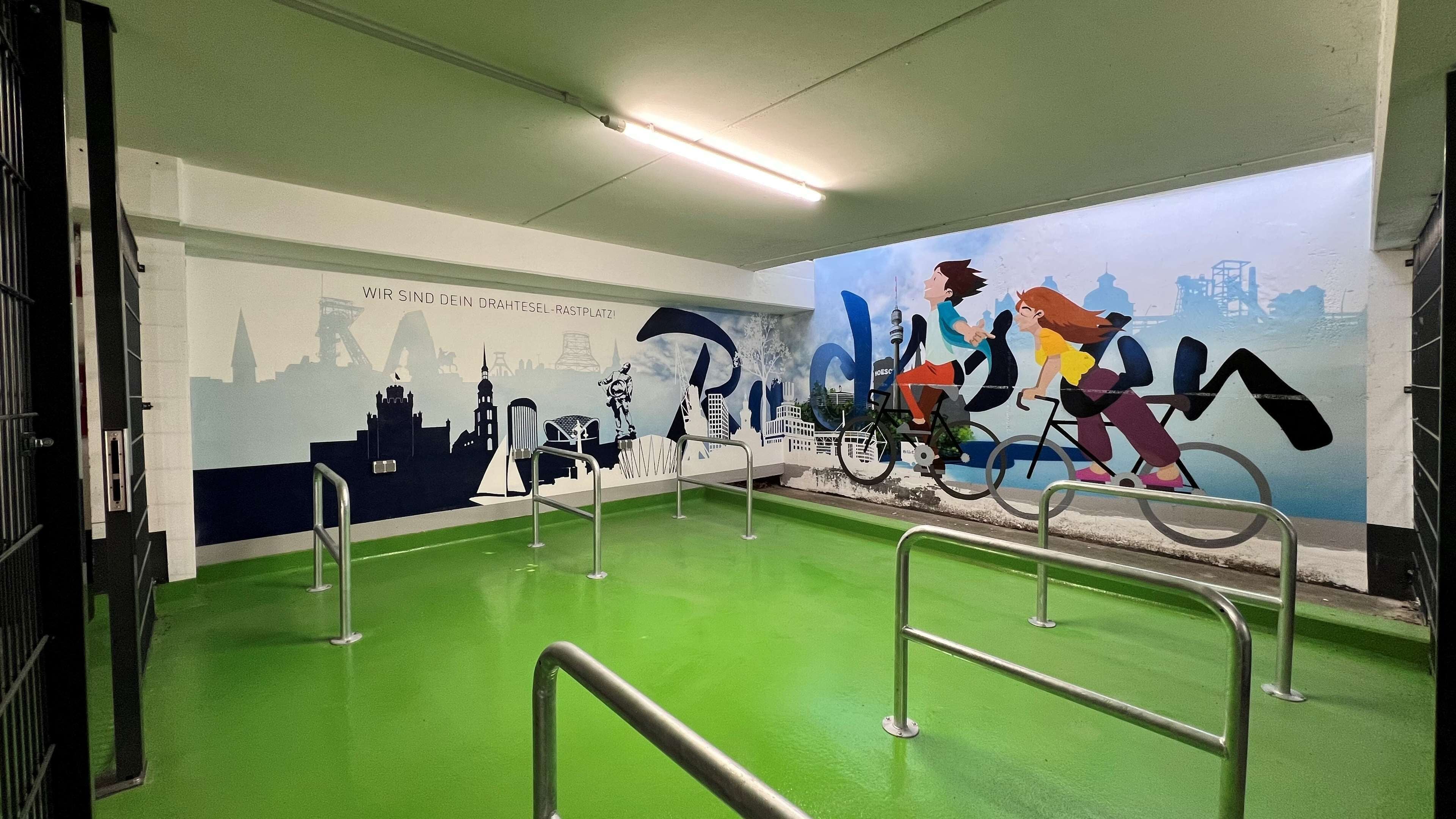 Ein grüner Innenbereich mit einem Wandgemälde von Radfahrern und Stadtansicht.