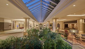 A spacious hotel lobby with a central atrium, multiple levels, and a glass ceiling. - Hyatt Regency Belgrade (Belgrade)