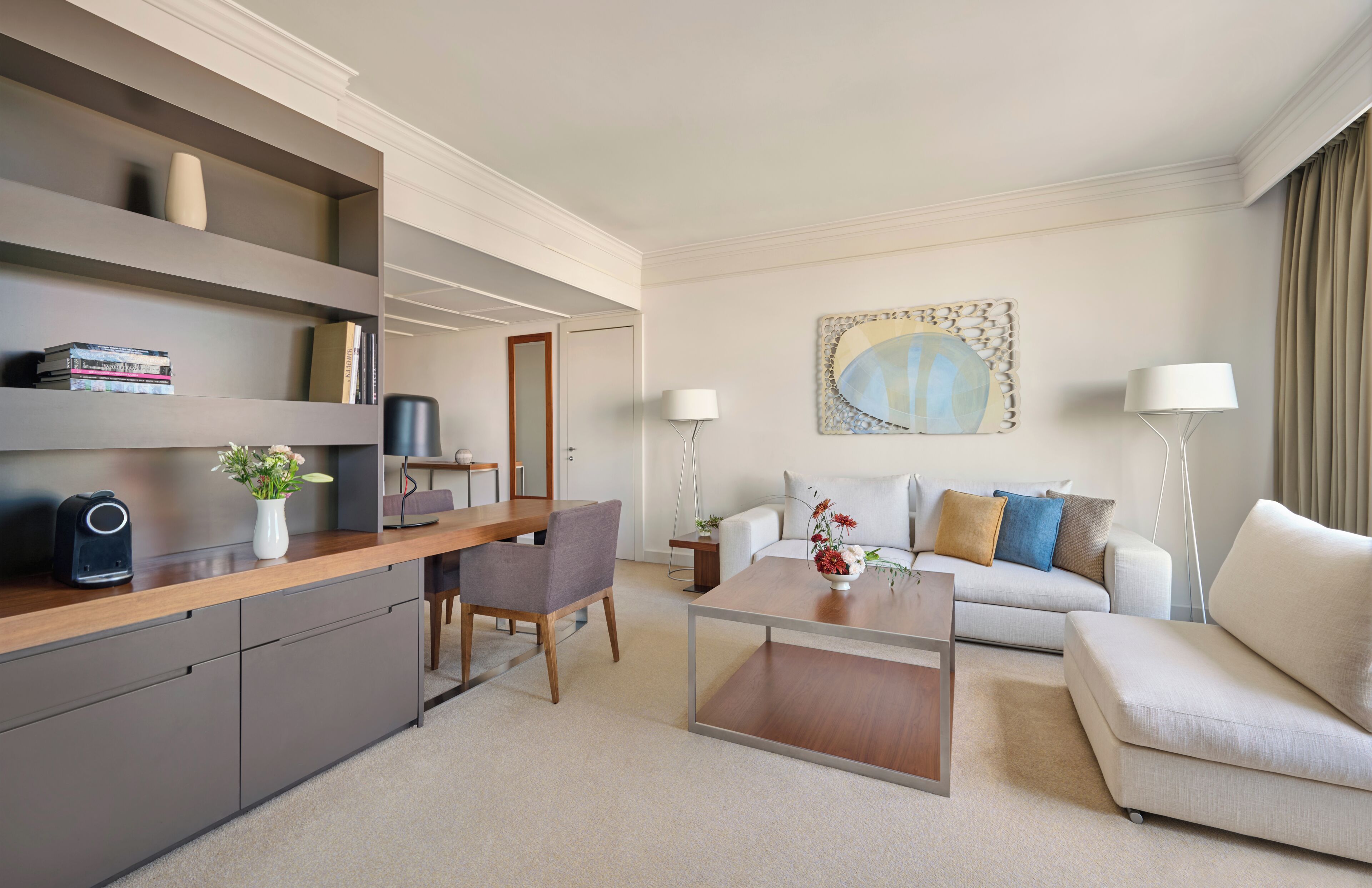 Un salon moderne comprenant un canapé, une table basse et un coin repas avec une chaise et une petite table.