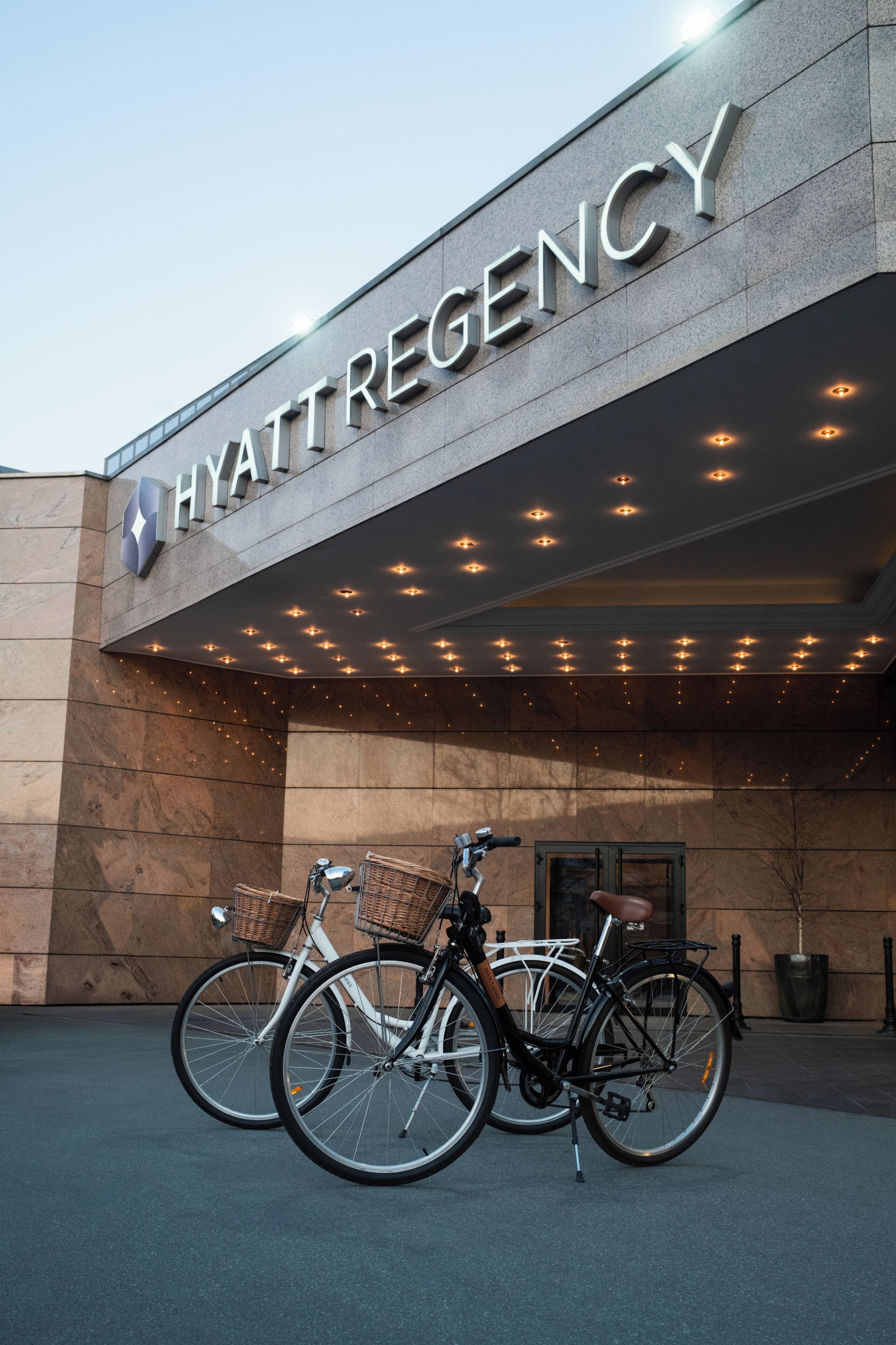 Hotellin sisäänkäynti, jossa on kyltti, jossa lukee ”HYATT REGENCY”, ja sen edessä on kaksi polkupyörää.