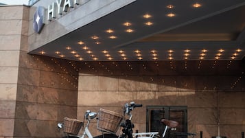 Hotellin sisäänkäynti, jossa on kyltti, jossa lukee ”HYATT REGENCY”, ja sen edessä on kaksi polkupyörää.