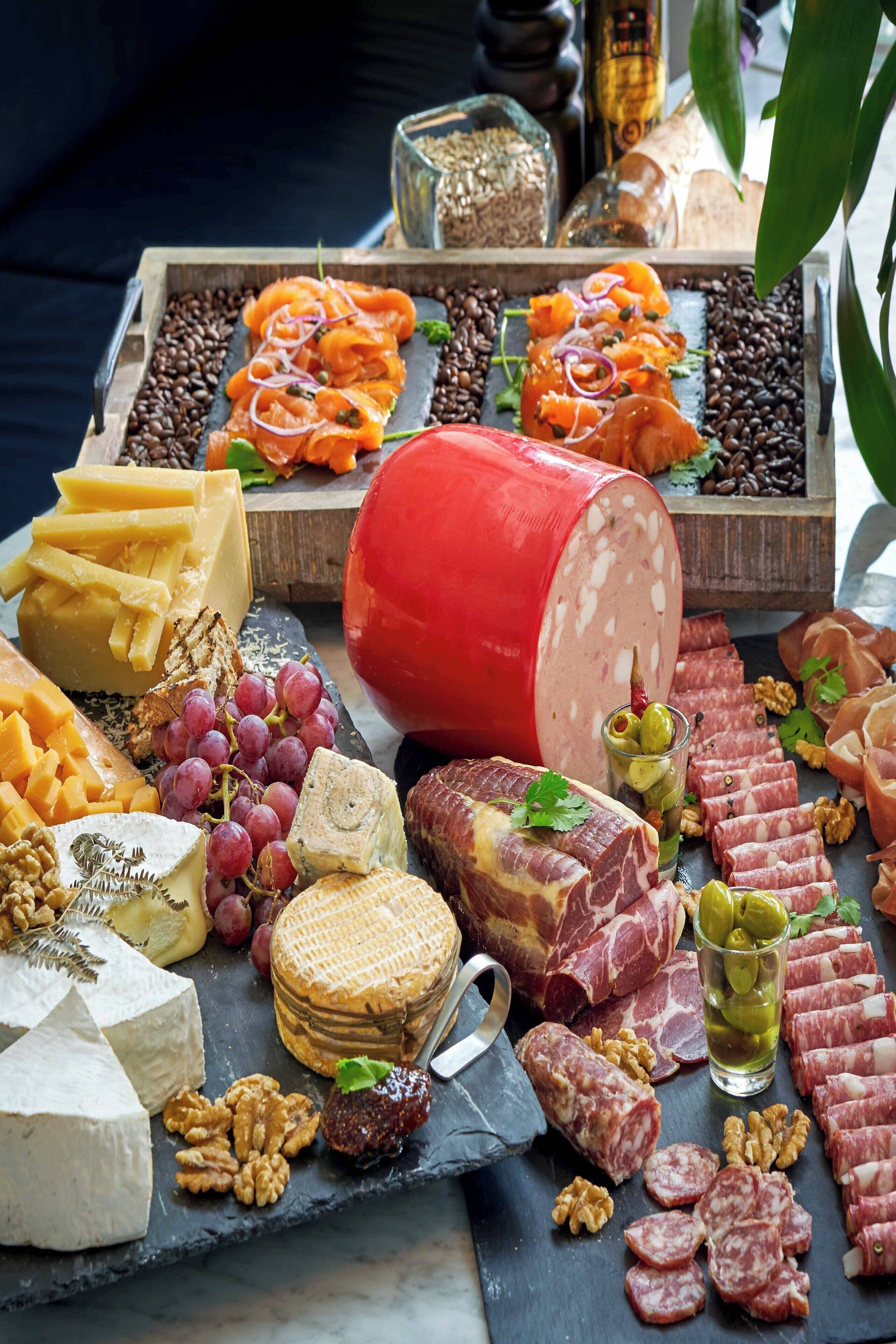 A charcuterie board with various cheeses, cured meats, and nuts.