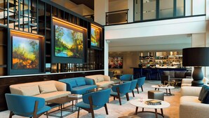 A modern lobby with a bar area, sofas, and a large painting on the wall. - The Hague Marriott Hotel (The Hague)