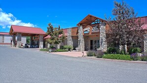 A hotel with a stone facade, red roof, and a sign indicating a restaurant and lounge. - Holiday Inn Cody - Convention Center by IHG (Cody)
