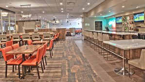 A spacious restaurant with multiple dining areas, a bar, and sports screens. - Holiday Inn Cody - Convention Center by IHG (Cody)