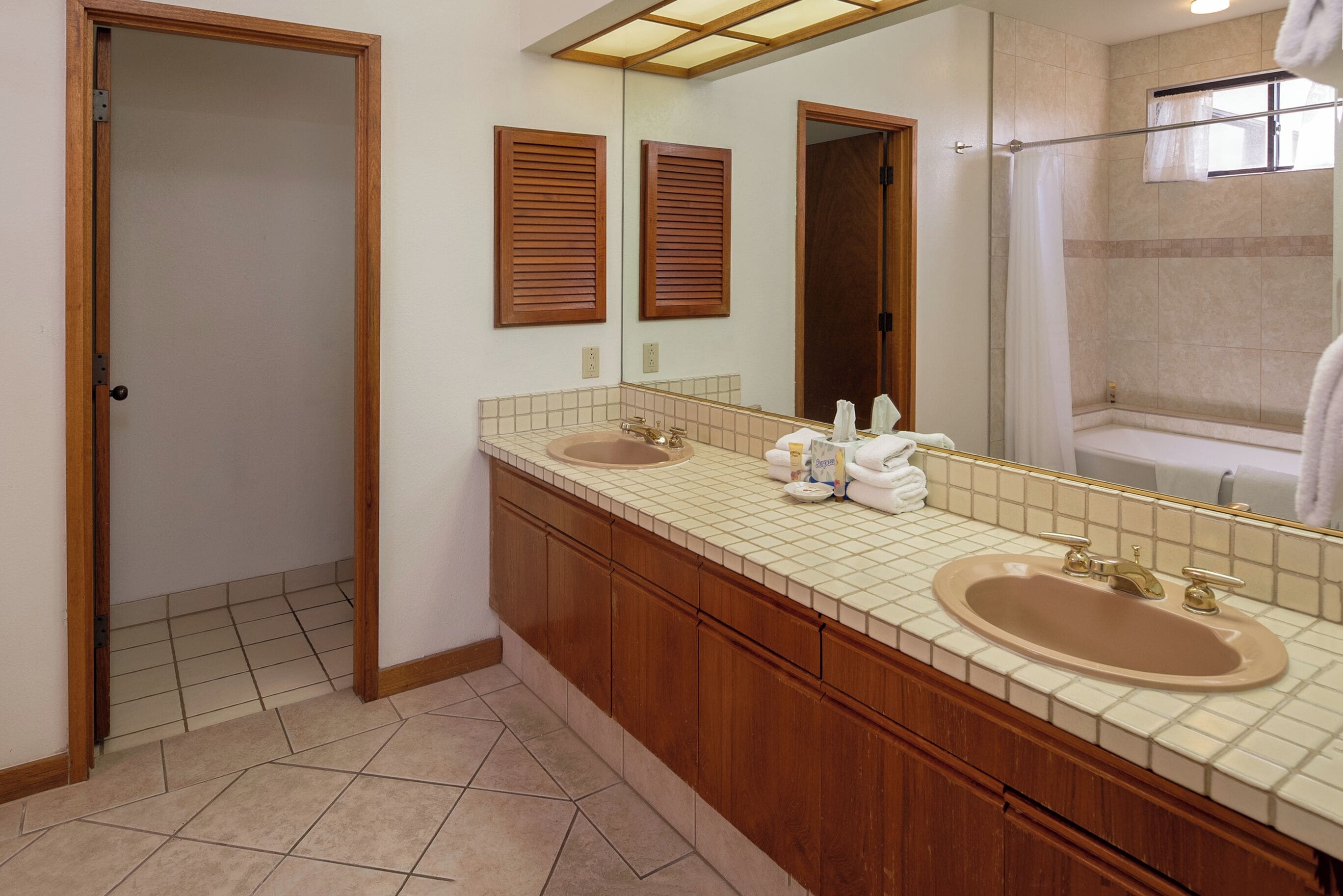 Une salle de bain avec deux lavabos, un miroir et une douche.