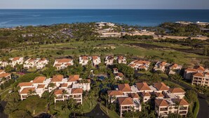 A residential area with houses featuring red-tiled roofs, surrounded by greenery and a golf course. - Shores at Waikoloa (Waikoloa)