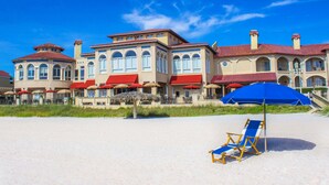A beachfront hotel with multiple stories, red awnings, and outdoor seating areas. - The Lodge and Club at Ponte Vedra Beach (Ponte Vedra Beach)