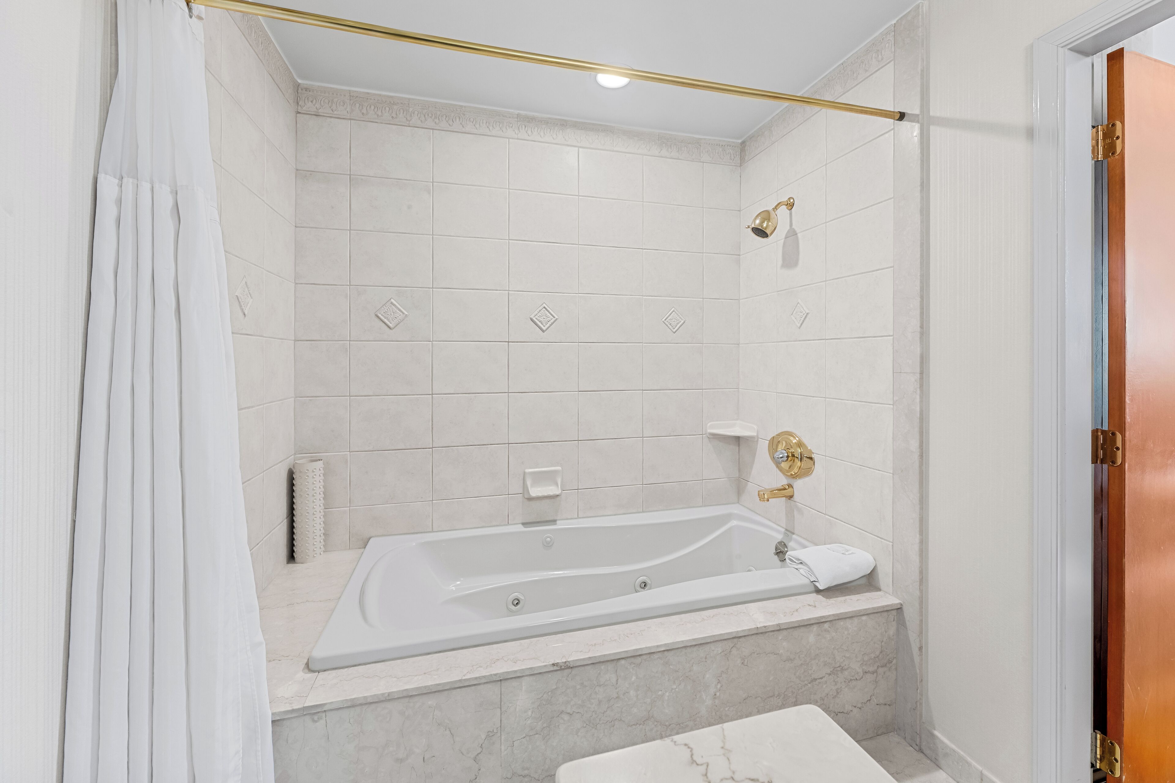 A modern bathroom with a freestanding bathtub, a showerhead, and a towel rack.