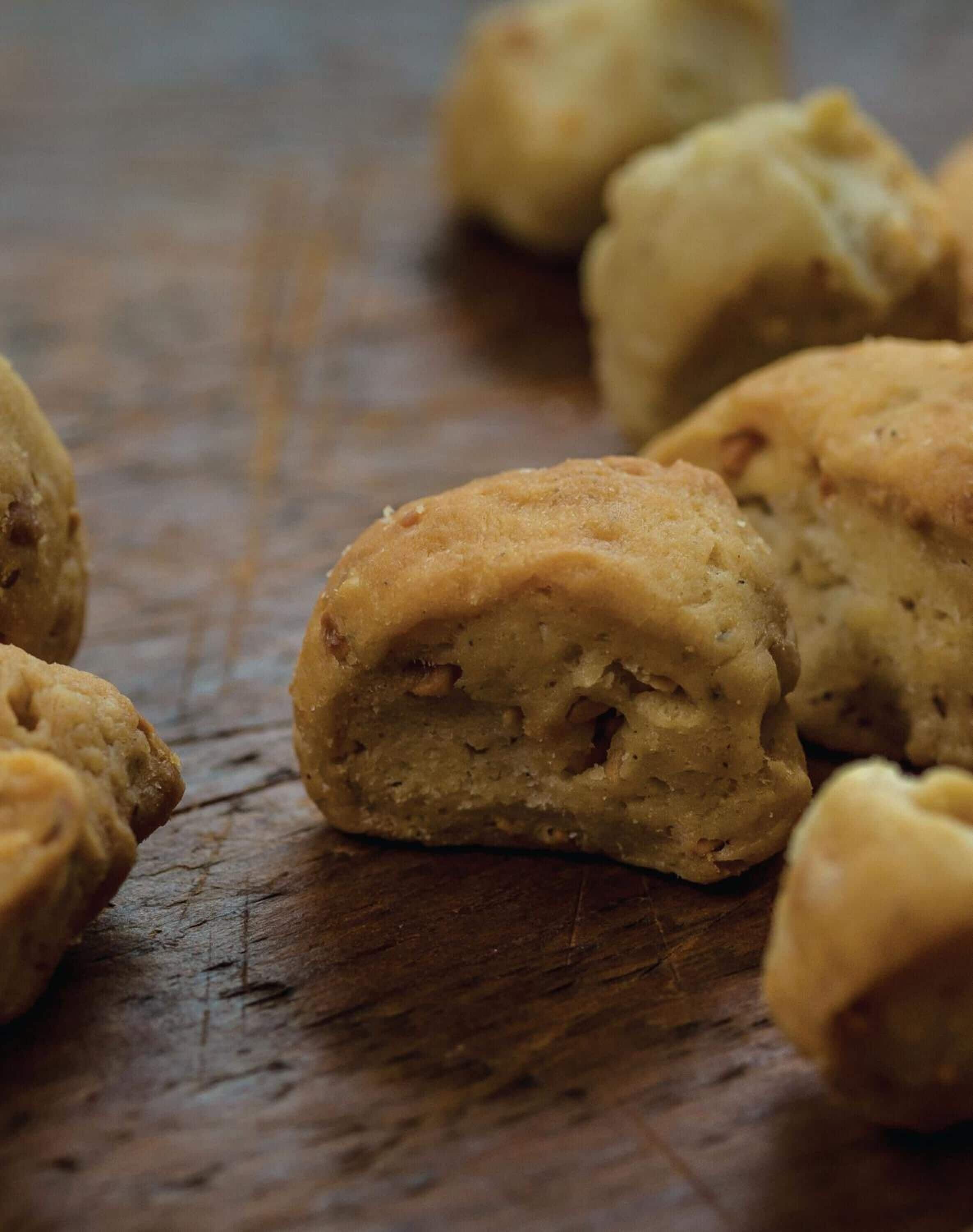 A close-up of several round, golden-brown baked goods on a wooden surface.