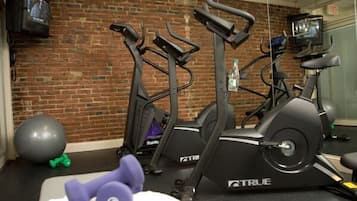 A gym with treadmills, a stationary bike, and exercise balls.