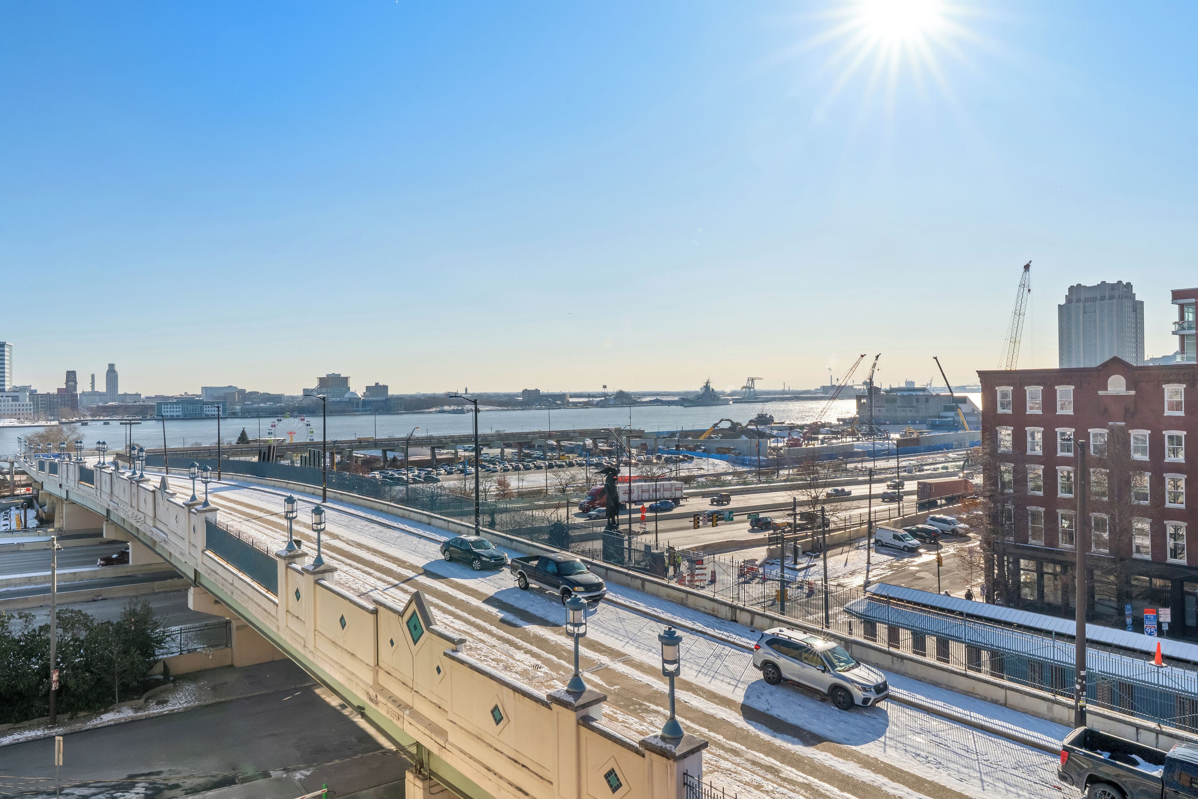 A bridge with multiple lanes, a parking area, and a river in the background.