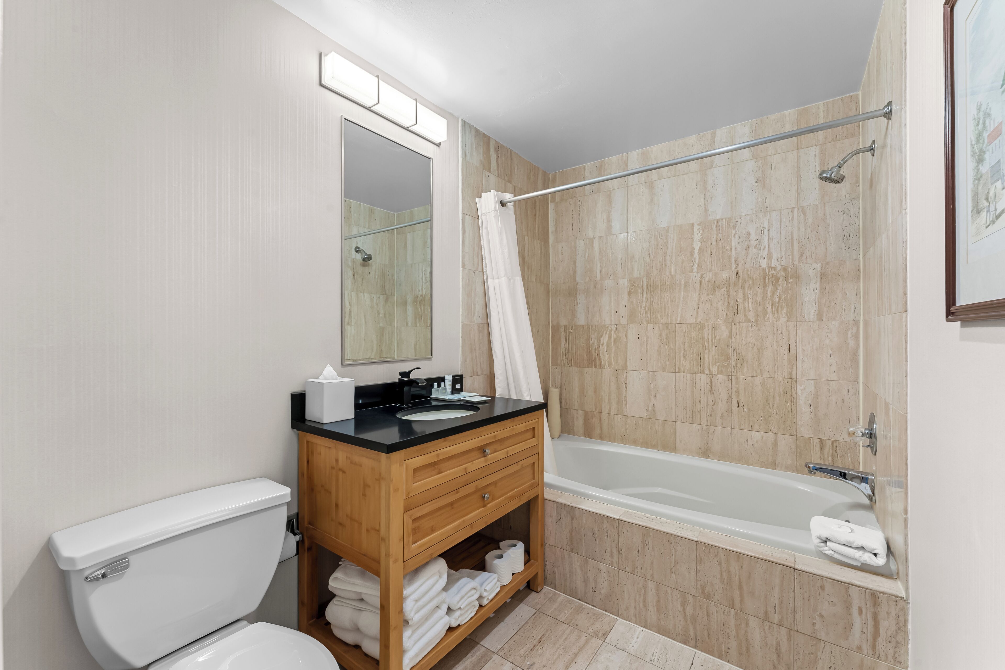 Un baño moderno con inodoro, lavabo, tocador y bañera.