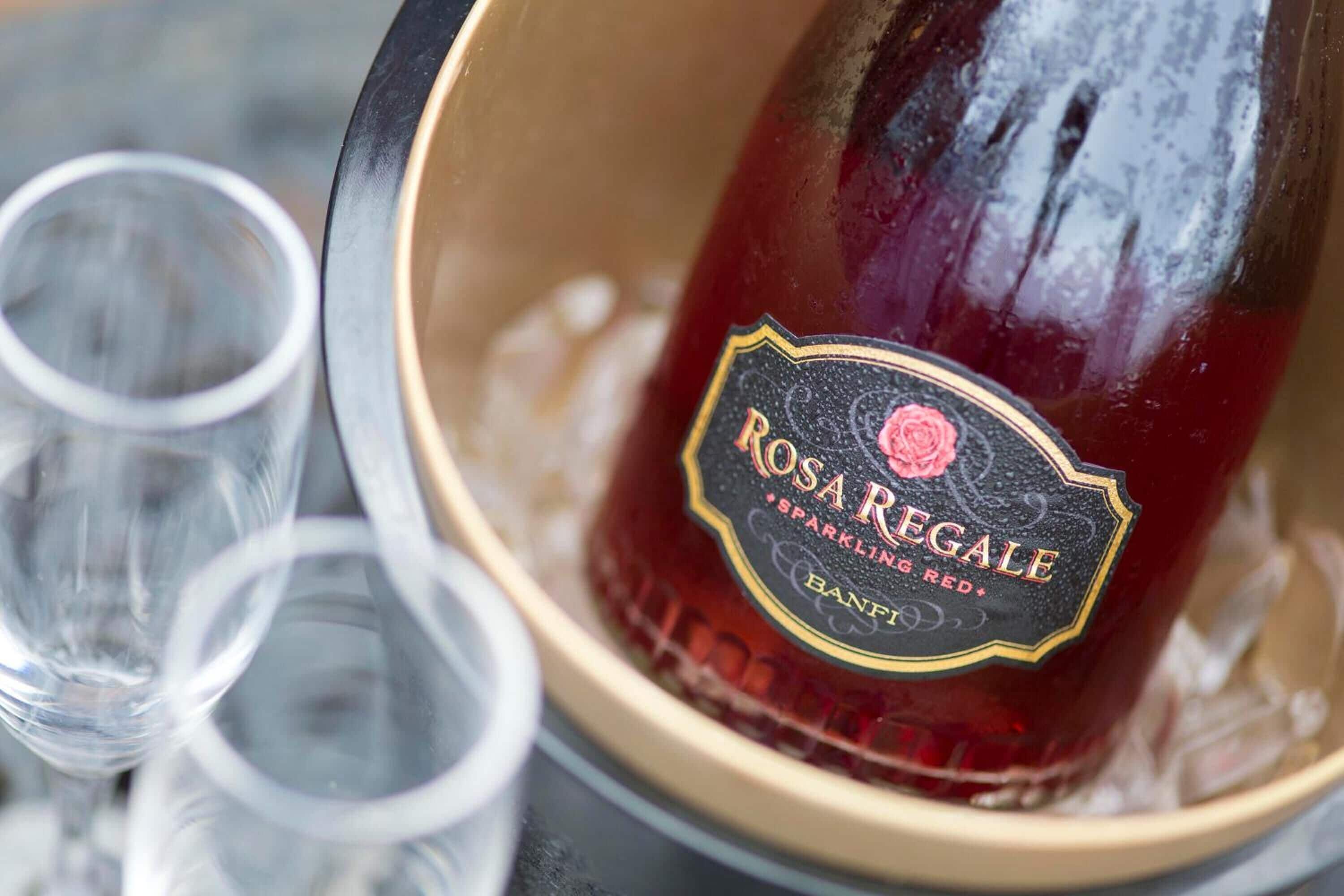 Una botella de vino tinto espumoso Rosa Regale en un balde con hielo.