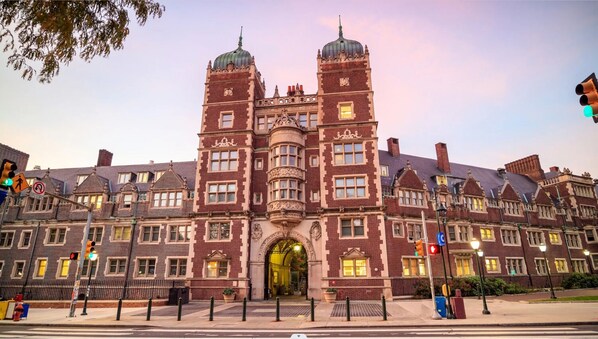 A large, historic building with a central entrance and two towers.