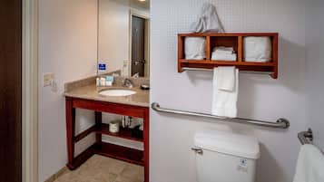A bathroom with a sink, mirror, towel rack, and toilet.