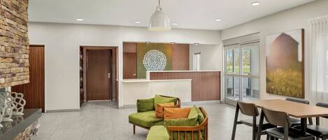 A modern living room with a sectional sofa, a wooden coffee table, and a dining area with a wooden table and chairs.