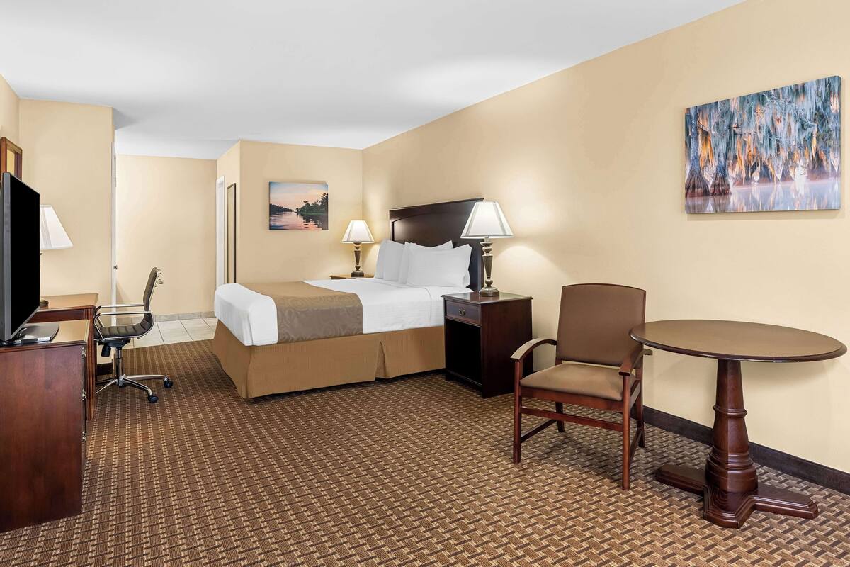 Une chambre d’hôtel équipée d’un lit, d’un bureau, d’une chaise et d’une table.