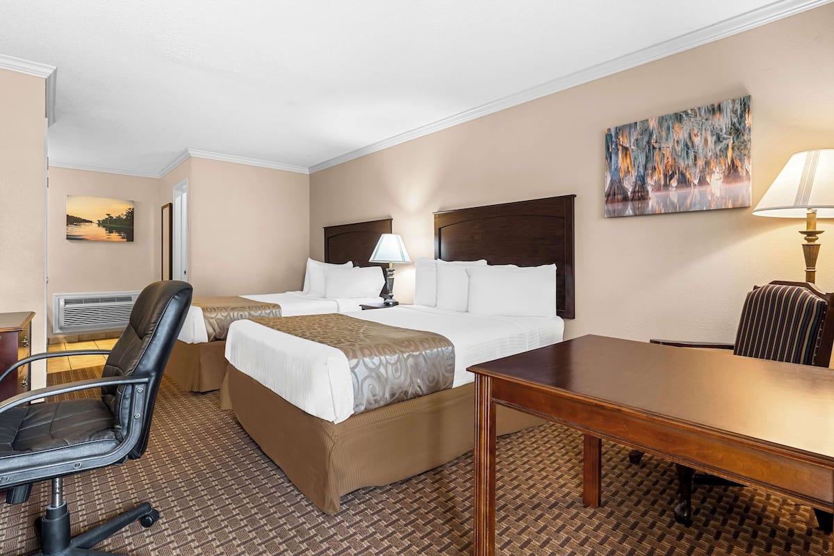 Une chambre d’hôtel avec un grand lit, un bureau, une chaise et une lampe.