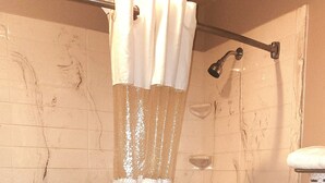 Un baño con bañera, cortina de ducha y un inodoro.