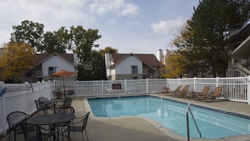 Een buitenzwembad, parasols bij het zwembad en ligstoelen