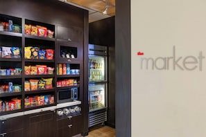 Una presentación de bocadillos con diversos alimentos envasados y una sección refrigerada con bebidas.