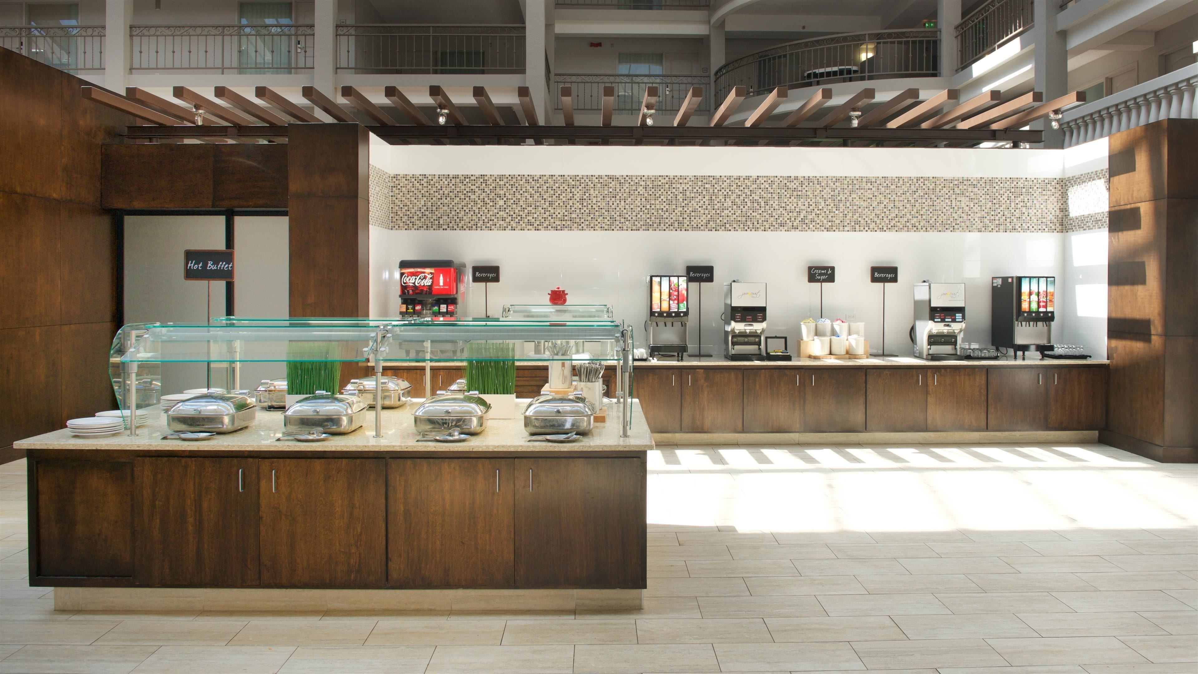 A buffet area with a glass display case, a Coca-Cola cooler, and beverage dispensers.