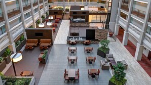 A multi-level hotel atrium with outdoor seating areas, multiple balconies, and a central open space with a fire feature. - Embassy Suites by Hilton Colorado Springs (Colorado Springs)