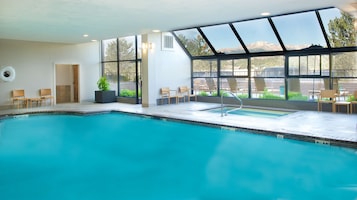 Una piscina techada, sillones reclinables de piscina