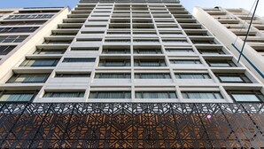 Un hotel moderno de gran altura, con fachada contemporánea, un logotipo destacado y una entrada con diseño geométrico.