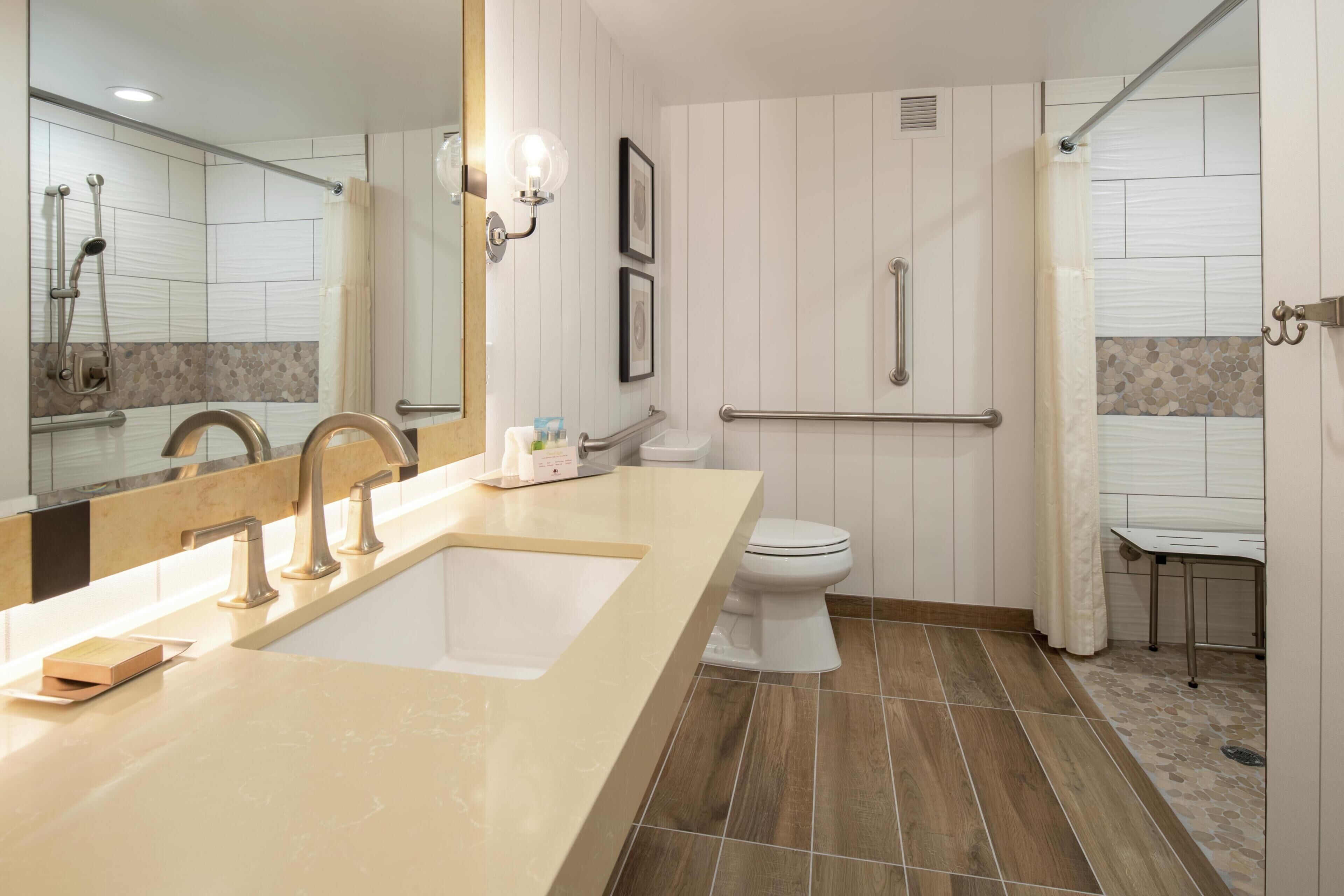A modern bathroom with a large sink, toilet, and shower area.