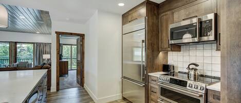 A modern kitchen with wooden cabinets, stainless steel appliances, and a large island.
