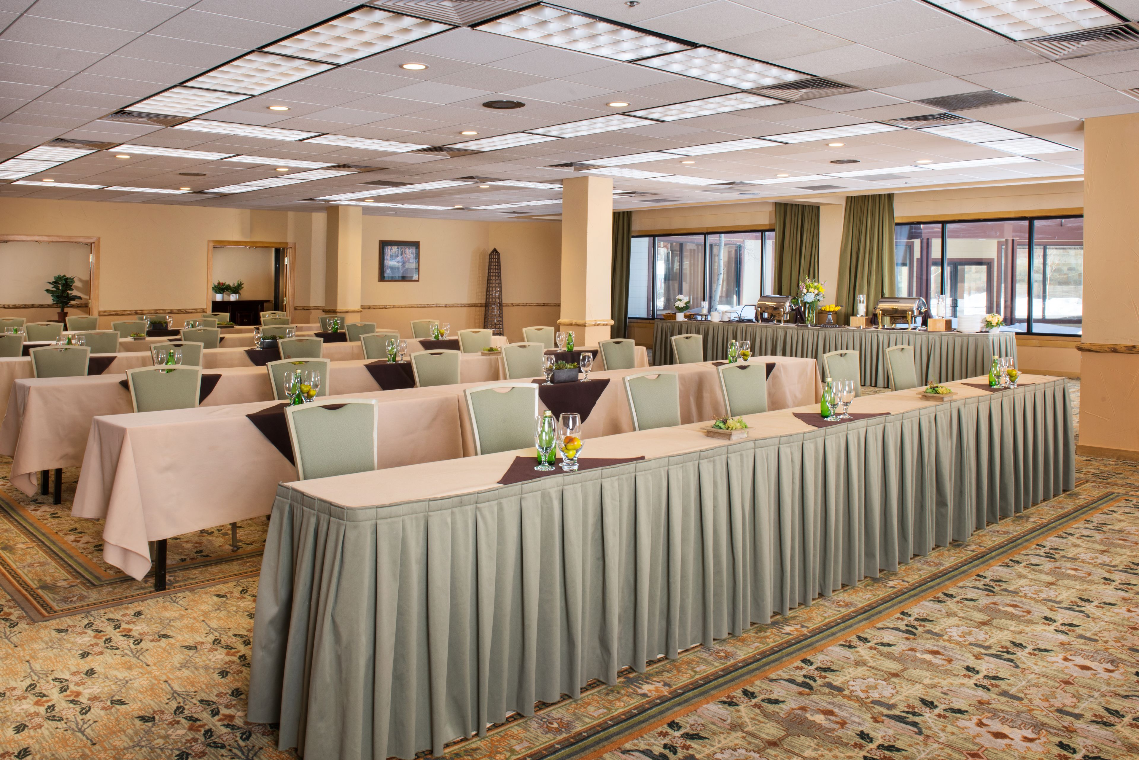 Una sala conferenze con diversi tavoli, sedie e un palco.
